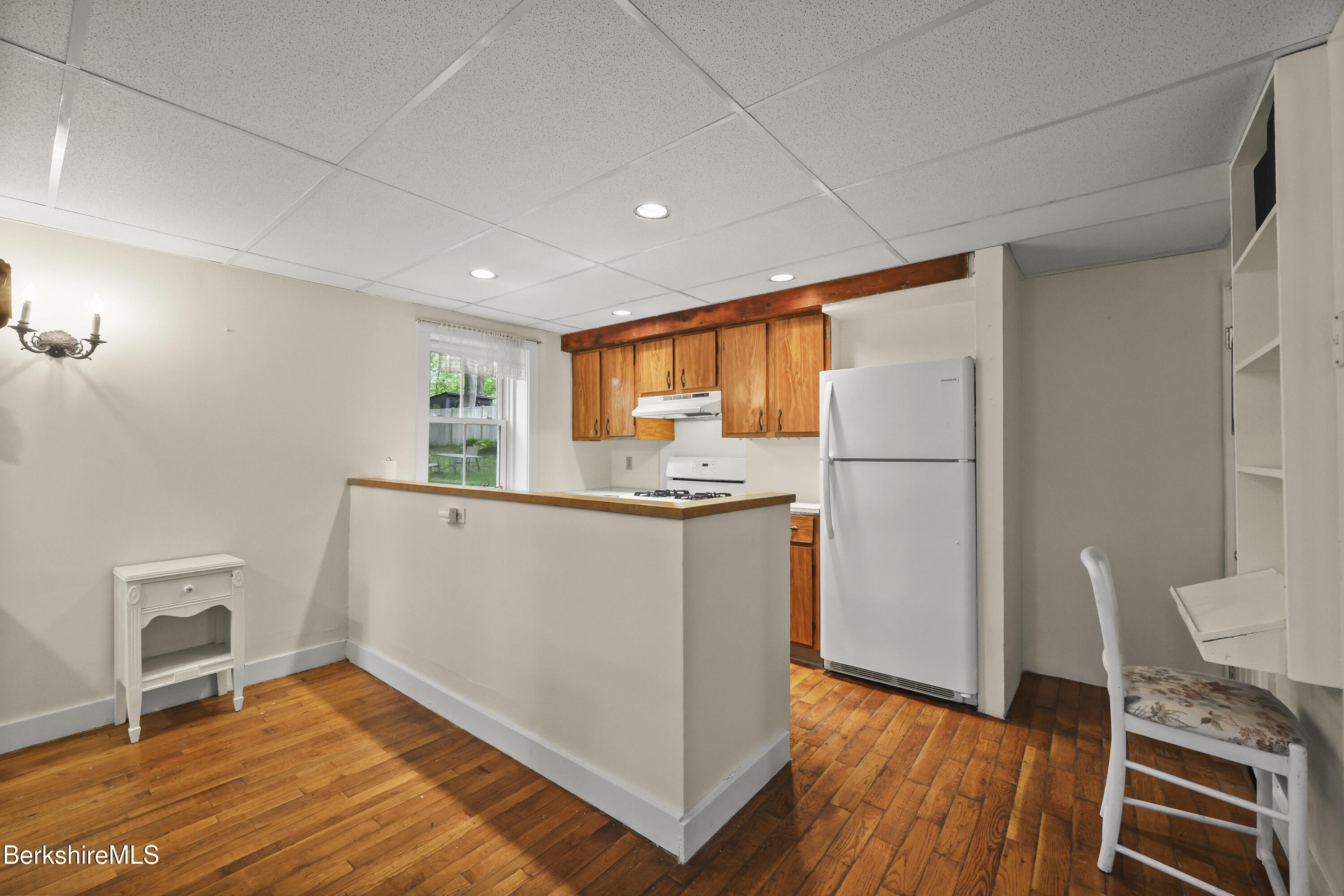 Kitchen with warm wood cabinets, hardwood floors, and a peninsula with a wood countertop.