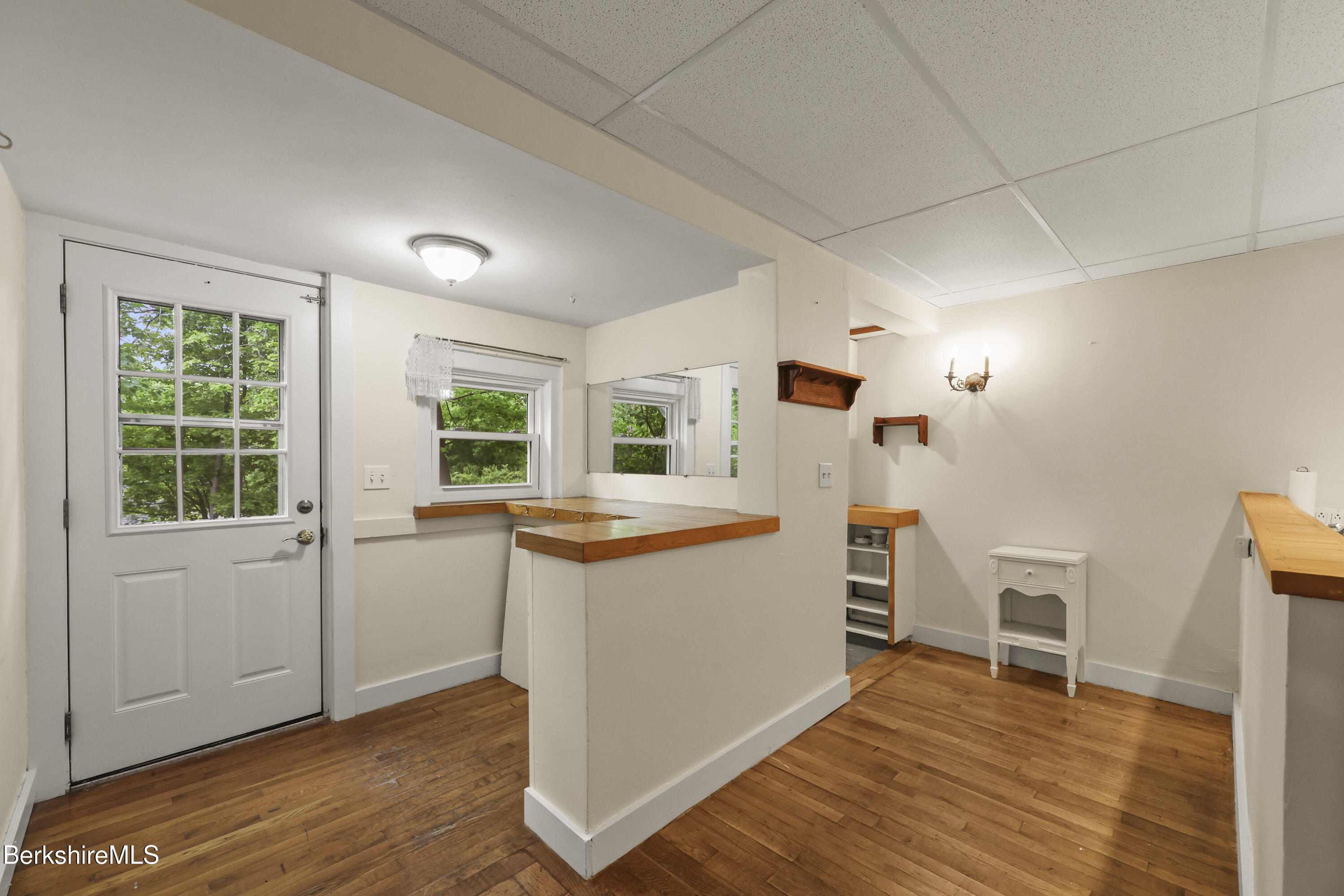 Interior with hardwood floors, mirrors, wooden counters, and a glass-paneled door.