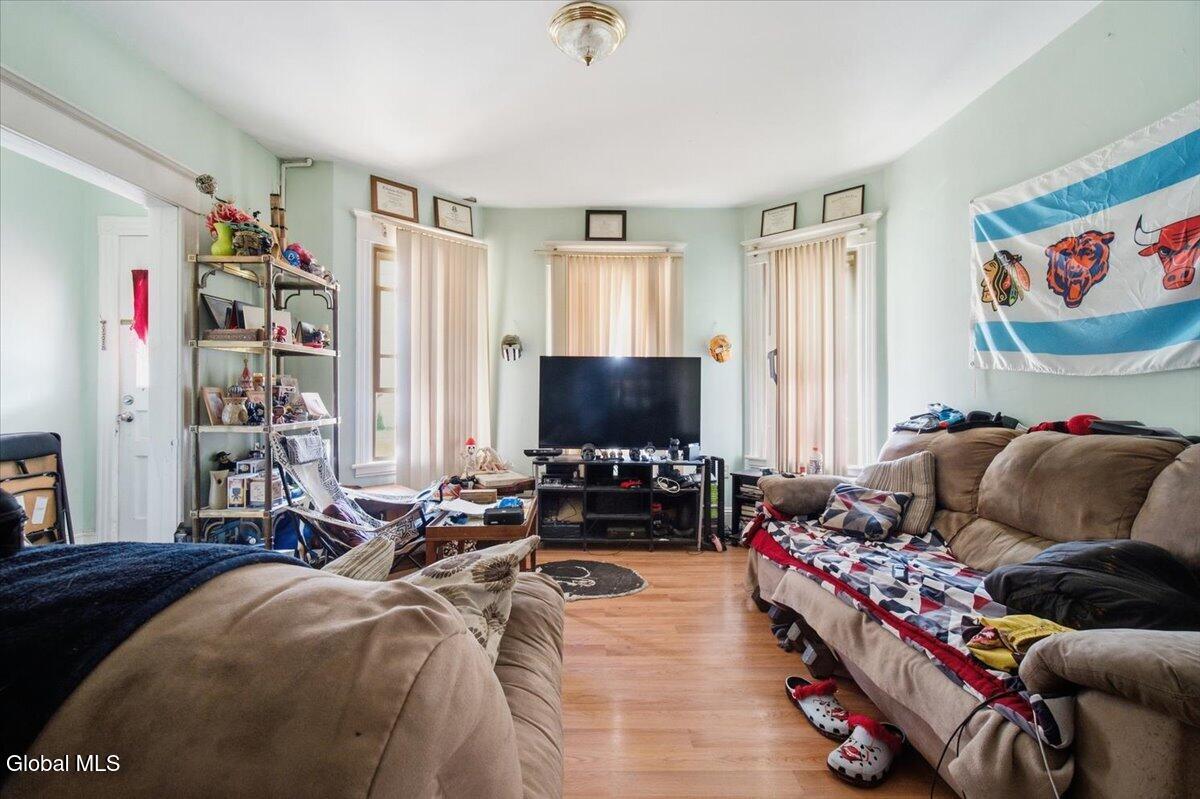 Living room with hardwood floors, tall windows, sofas, and a Chicago flag.