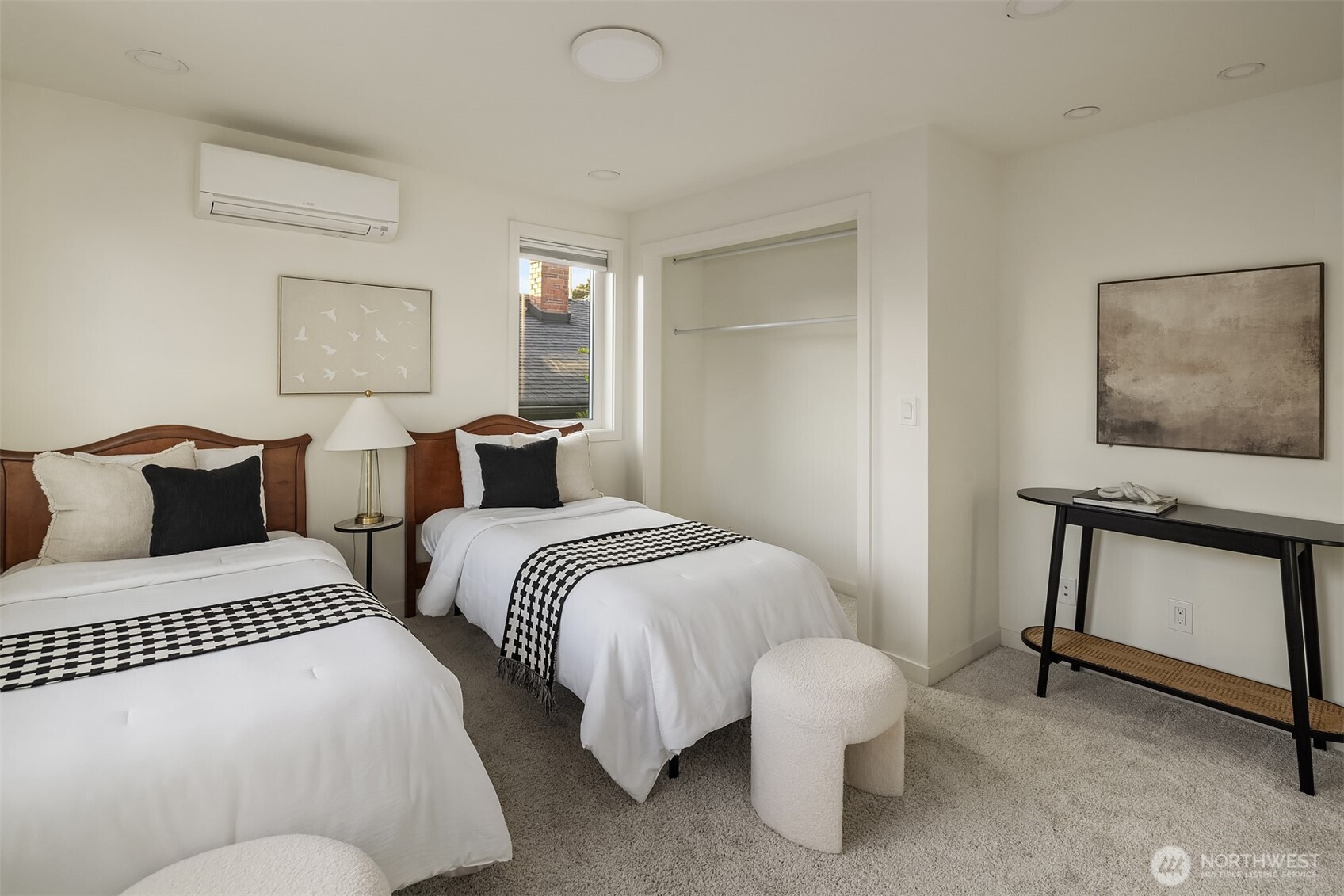 Bedroom with two twin beds, patterned runners, and an open closet.