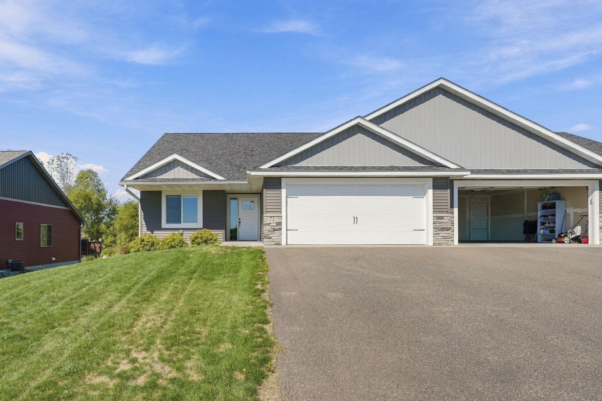 Gray gabled home with a double garage and an open single-car garage beside the driveway.
