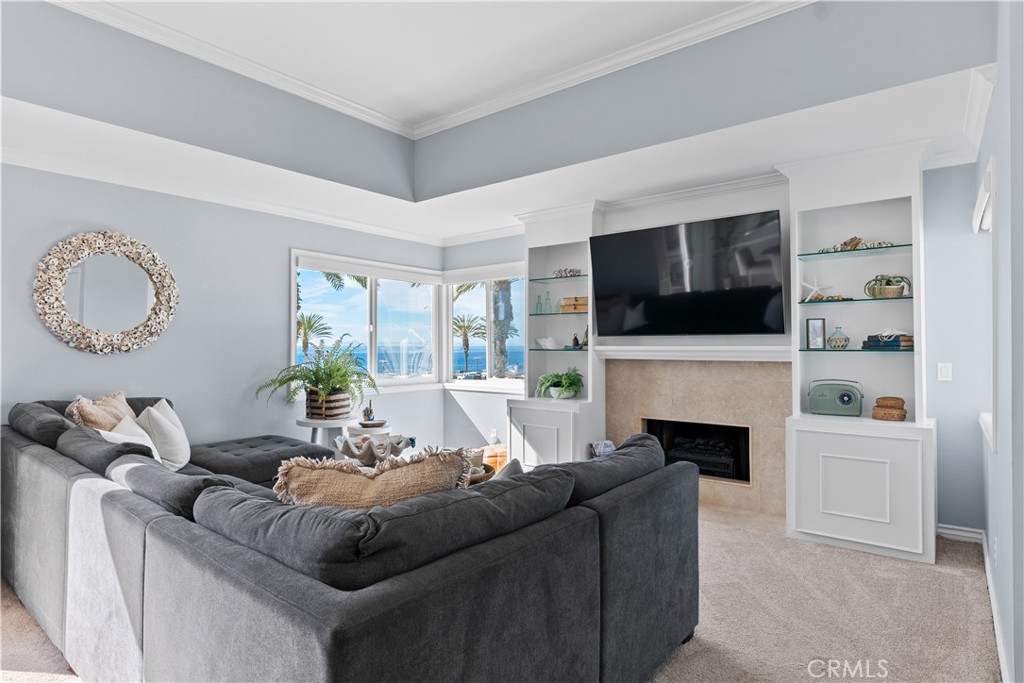 Living room with a built-in fireplace and ocean views through corner windows.