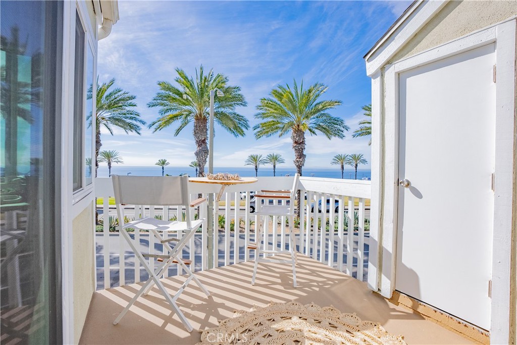 Furnished balcony with palm trees and an ocean view.