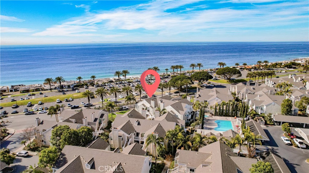 Coastal condominiums beside the Pacific, with a pool and red location pin.