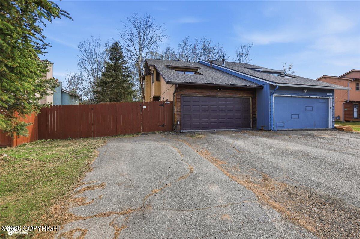 Home at 2620 W 72nd Avenue with two garage doors and a wide paved driveway.