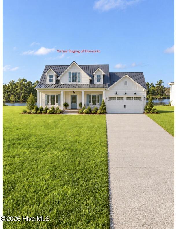 White two-story house with a dark metal roof, attached garage, and water visible behind it.