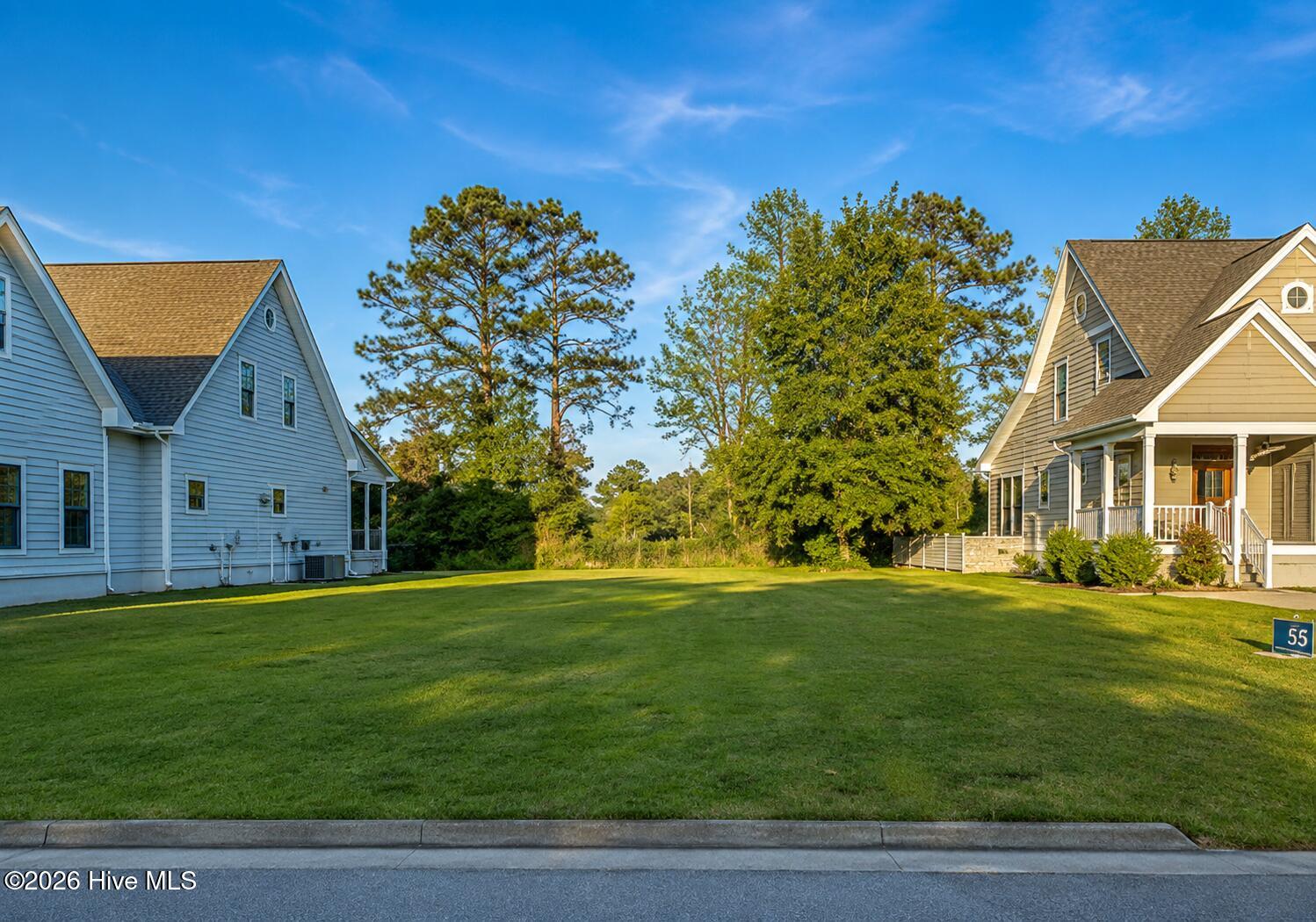 House marked 55 with a covered porch, broad lawn, and mature trees.