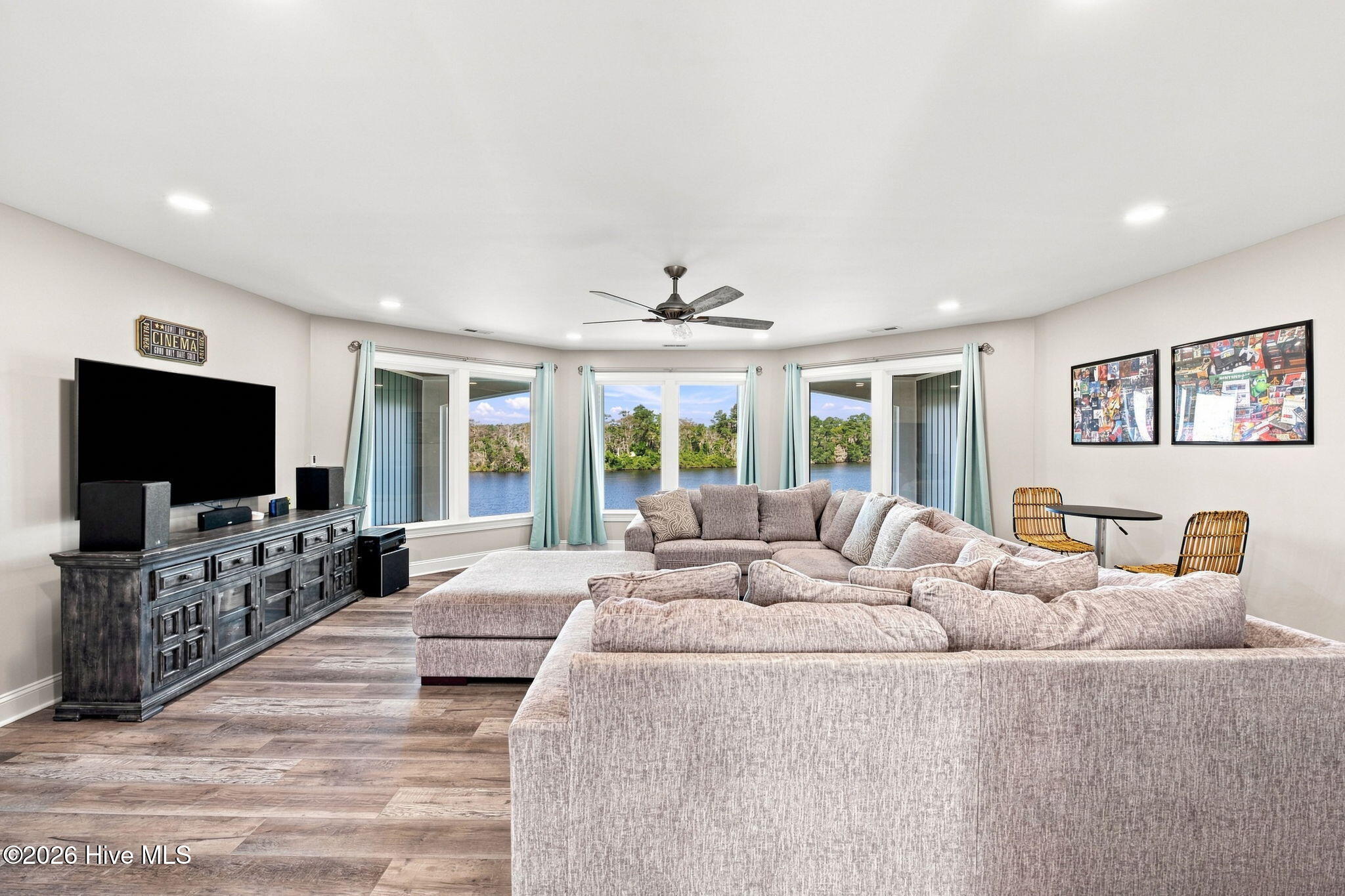 Furnished living room with a large sectional sofa and wide windows overlooking the water.