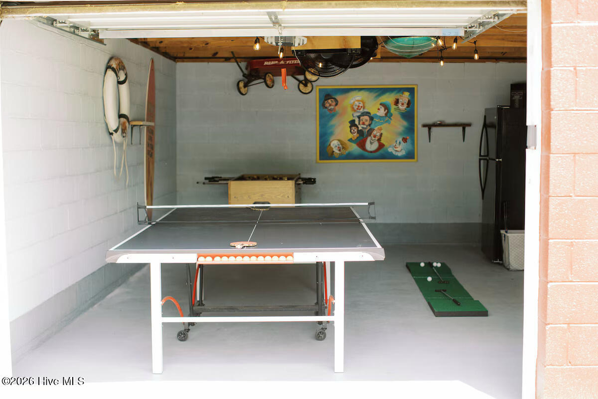 Garage game room with a ping-pong table and putting green.