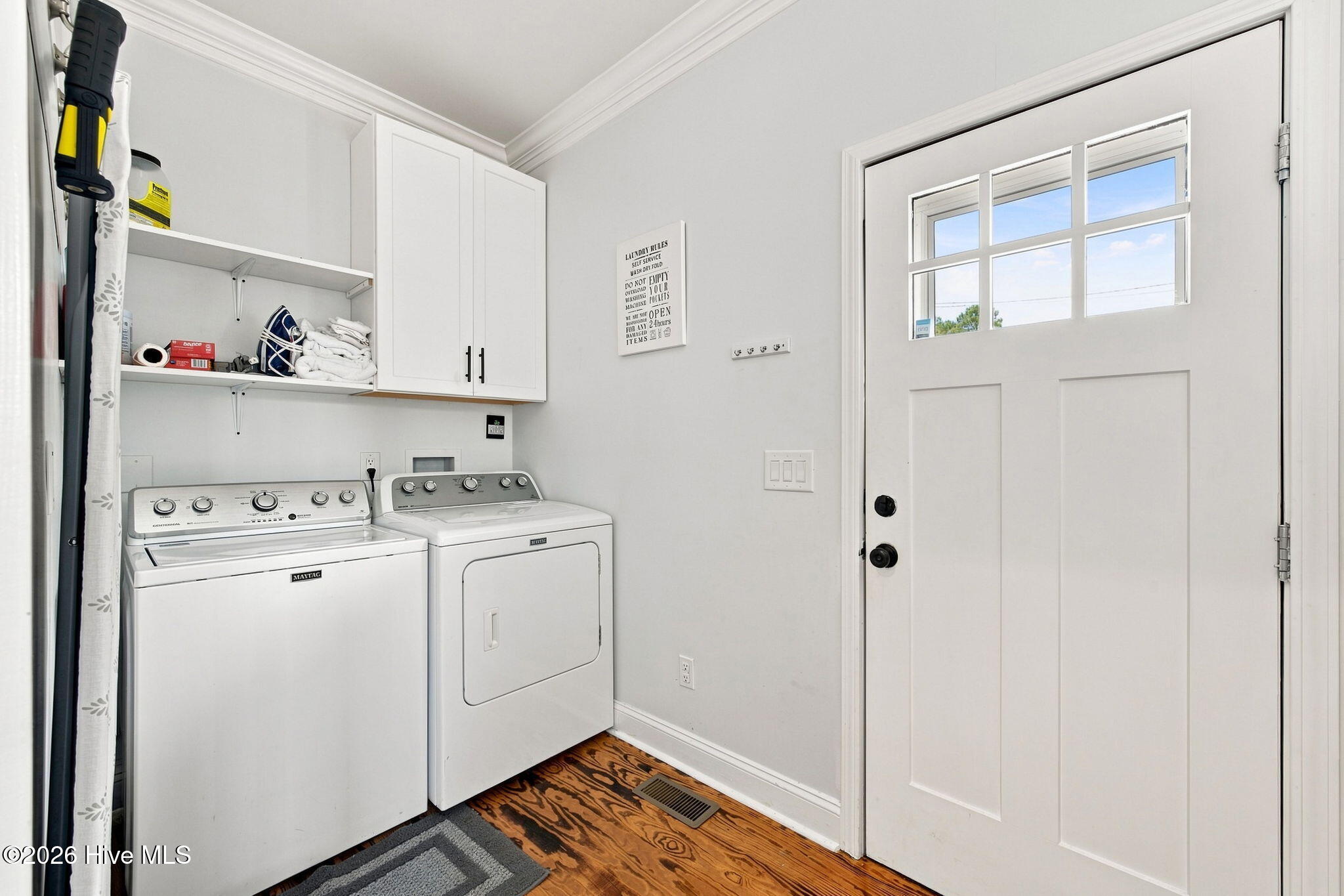 Laundry room with washer and dryer, white storage cabinets, and a windowed exterior door.