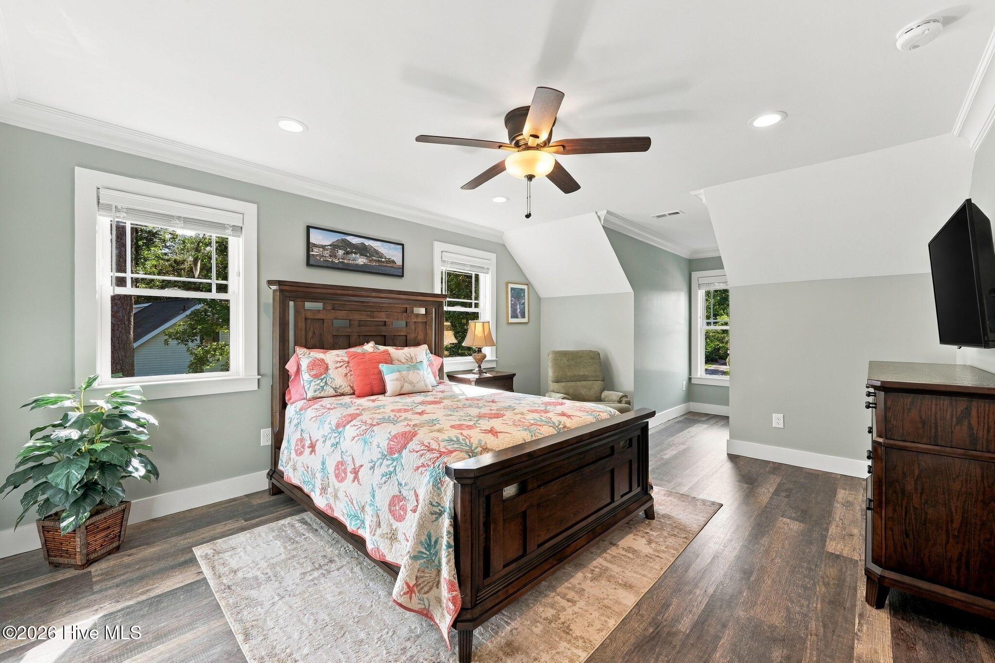 Bedroom with a dark wood bed, floral bedding, and a ceiling fan.