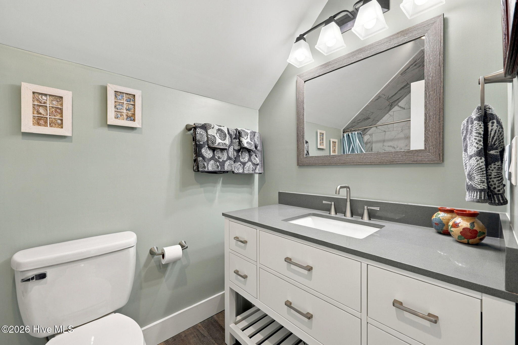 Bathroom with a white vanity, gray countertop, large mirror, and toilet.