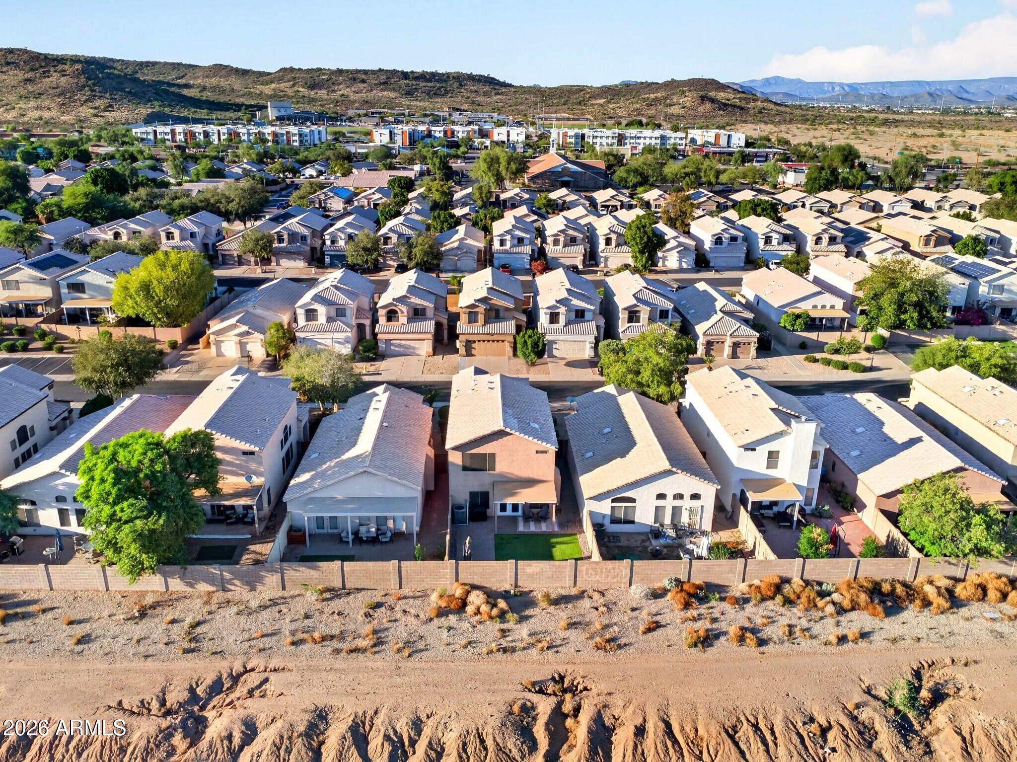 Aerial view of a Glendale neighborhood, with rows of homes below desert foothills and distant mountains.
