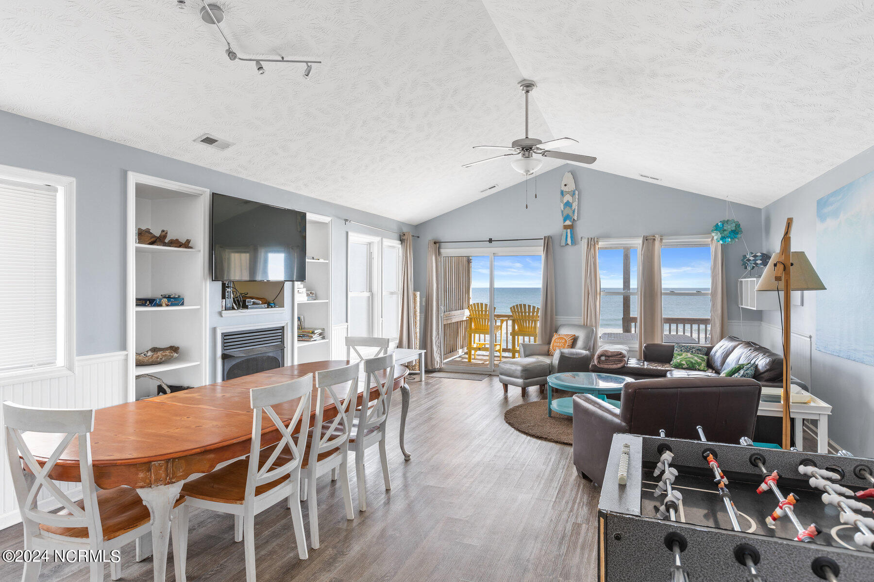 Open living and dining room with leather seating and ocean views through the windows.