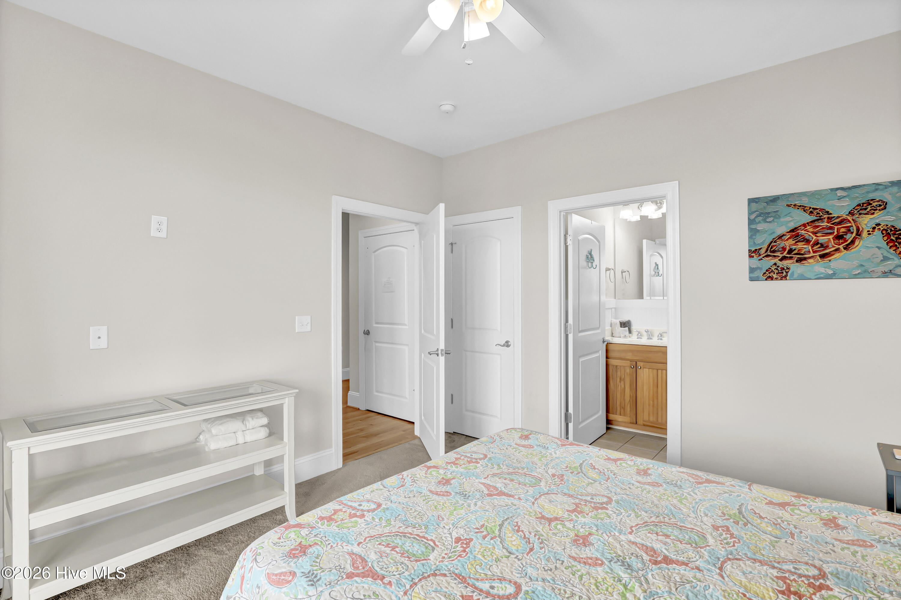 Bedroom with a colorful paisley bedspread and an open doorway to the en-suite bathroom.