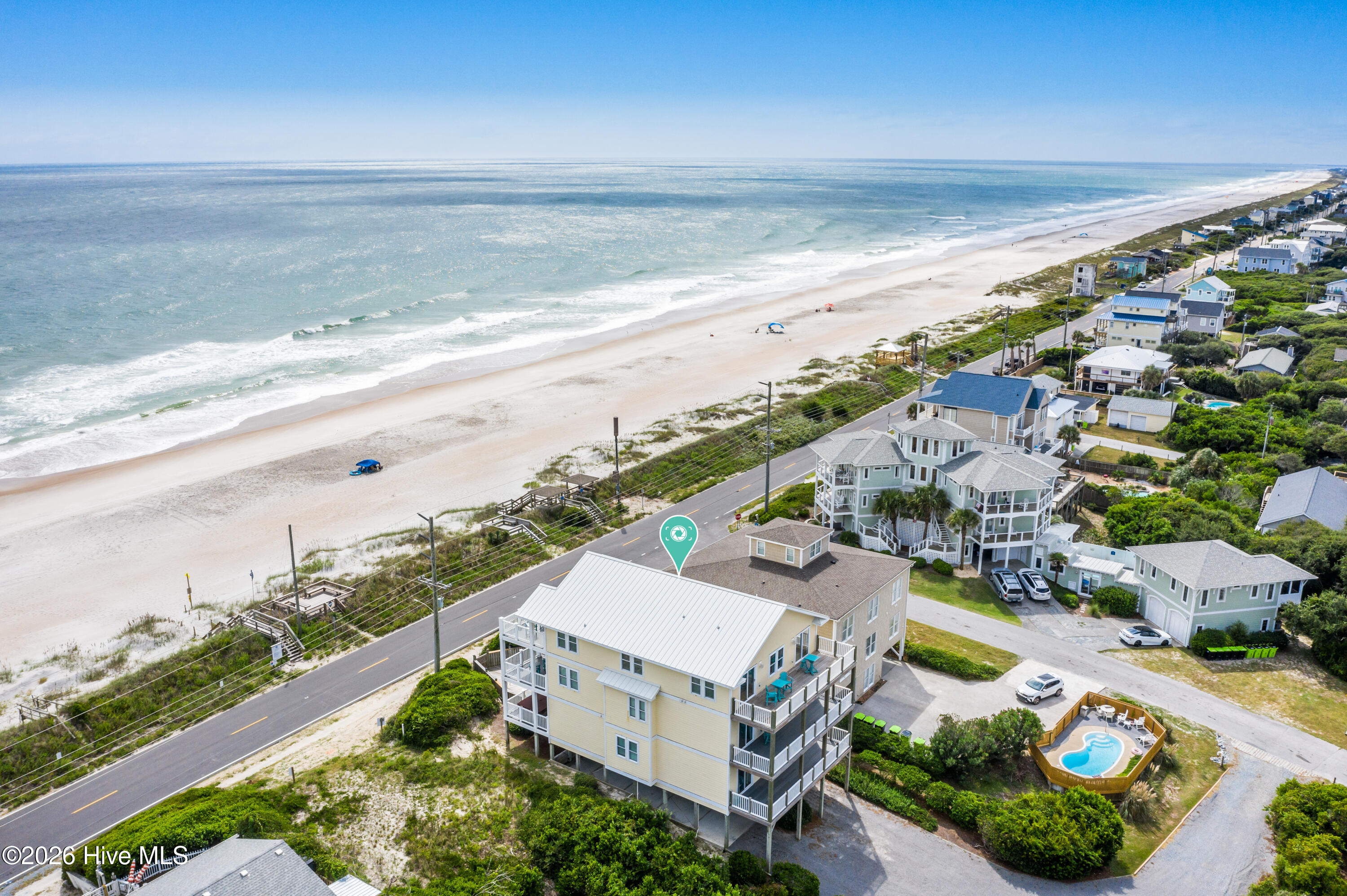 Coastal home beside a sandy beach, with a private pool and oceanfront views.