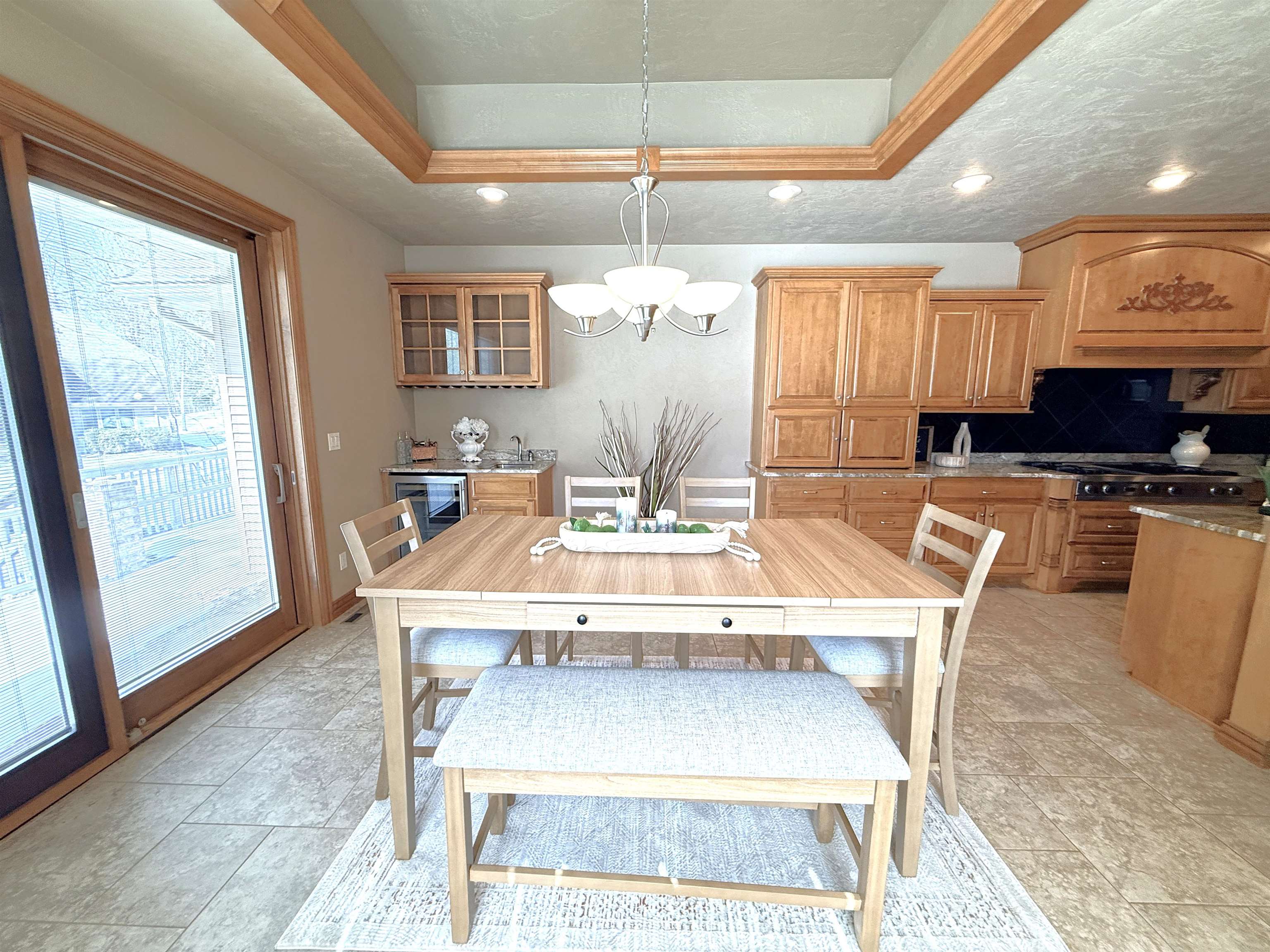 Kitchen and dining area with wood cabinets, a central table, and a glass patio door.