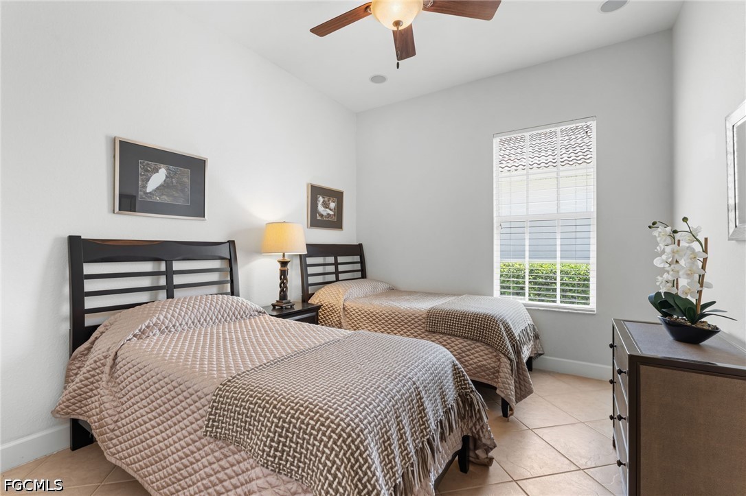Bedroom with two twin beds, neutral bedding, and a large window with white blinds.