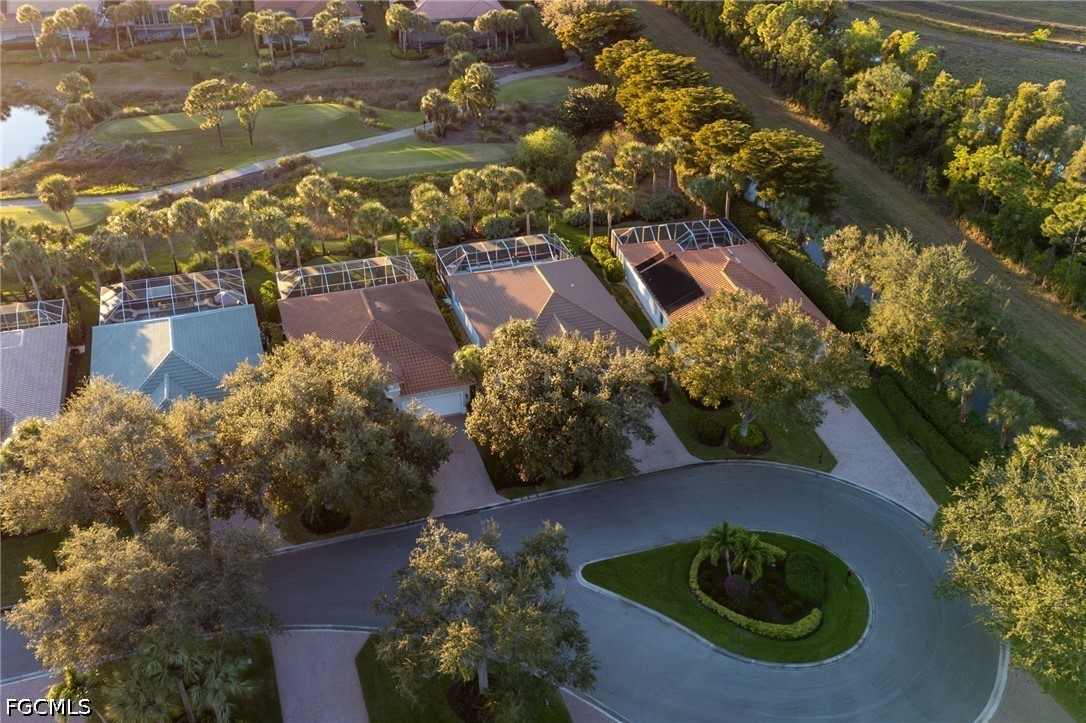Aerial view of homes on a landscaped cul-de-sac, with screened pool enclosures and mature trees.