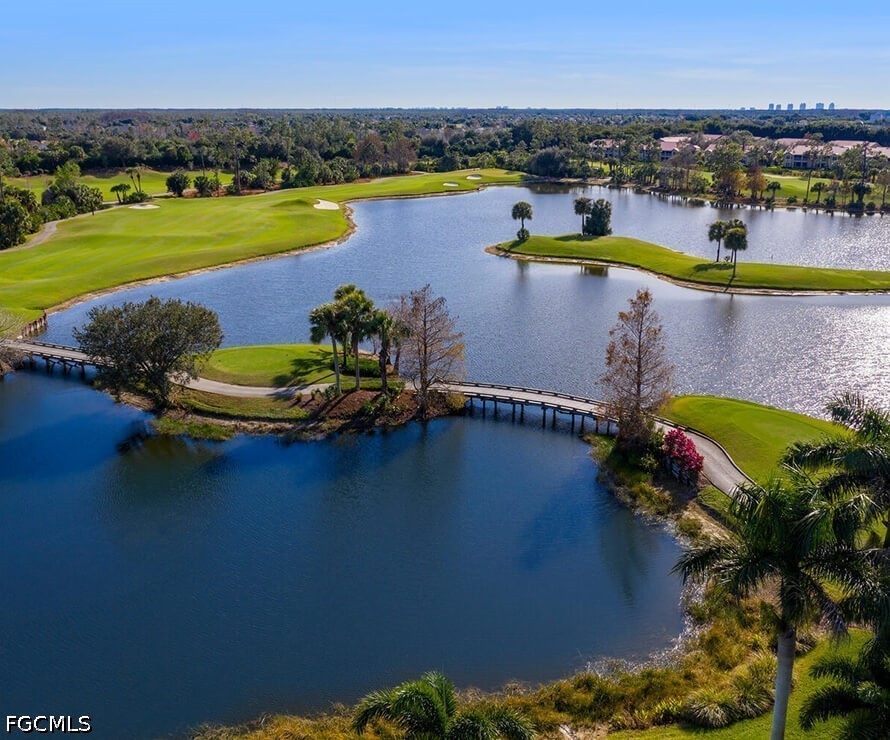 Aerial golf course surrounding a lake, with landscaped islands and a footbridge.