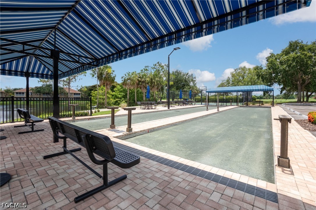 Community bocce ball courts beneath striped canopies, with benches and tropical landscaping.