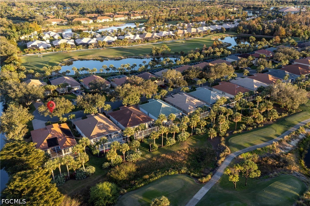 Aerial view of a home marked by a red pin beside a golf course and pond.