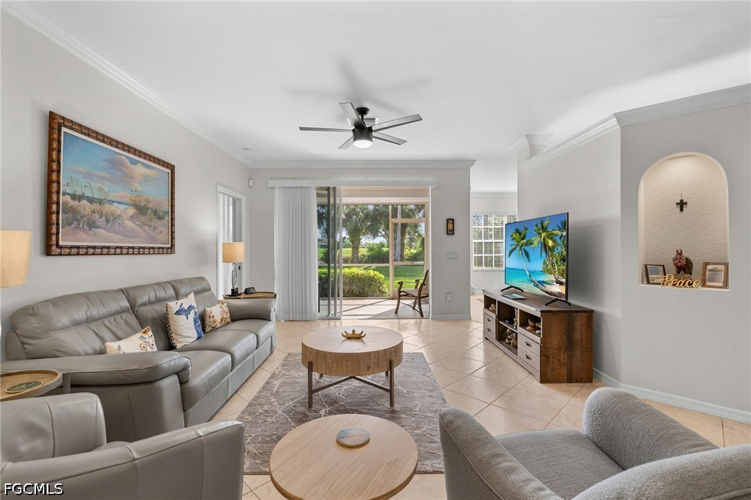 Furnished living room with gray leather seating, sliding glass doors, and a landscaped yard view.