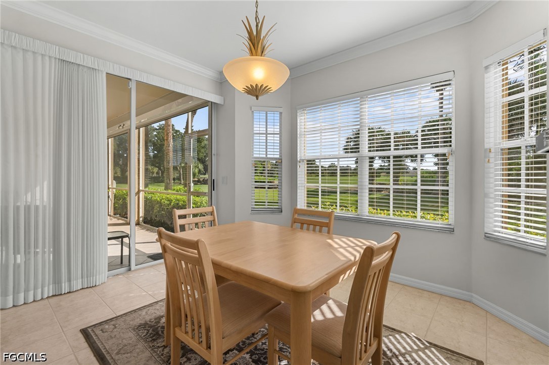 Dining room with a light wood table, sliding glass doors, and views of a manicured green.