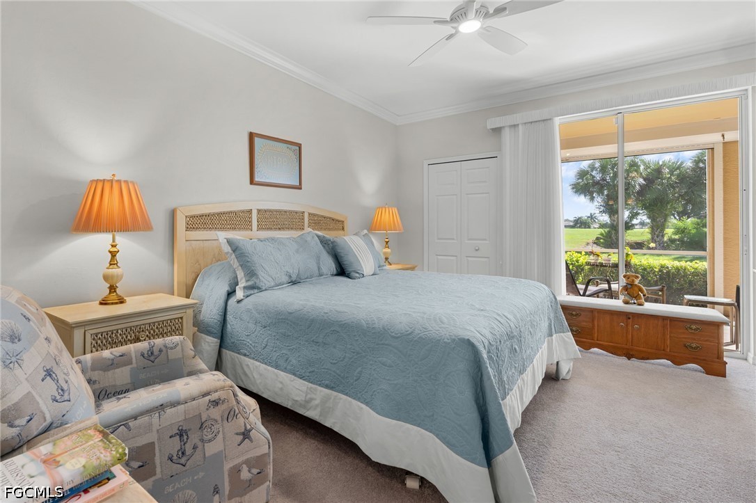 Bedroom with a king bed and sliding glass door overlooking palm trees and a green lawn.