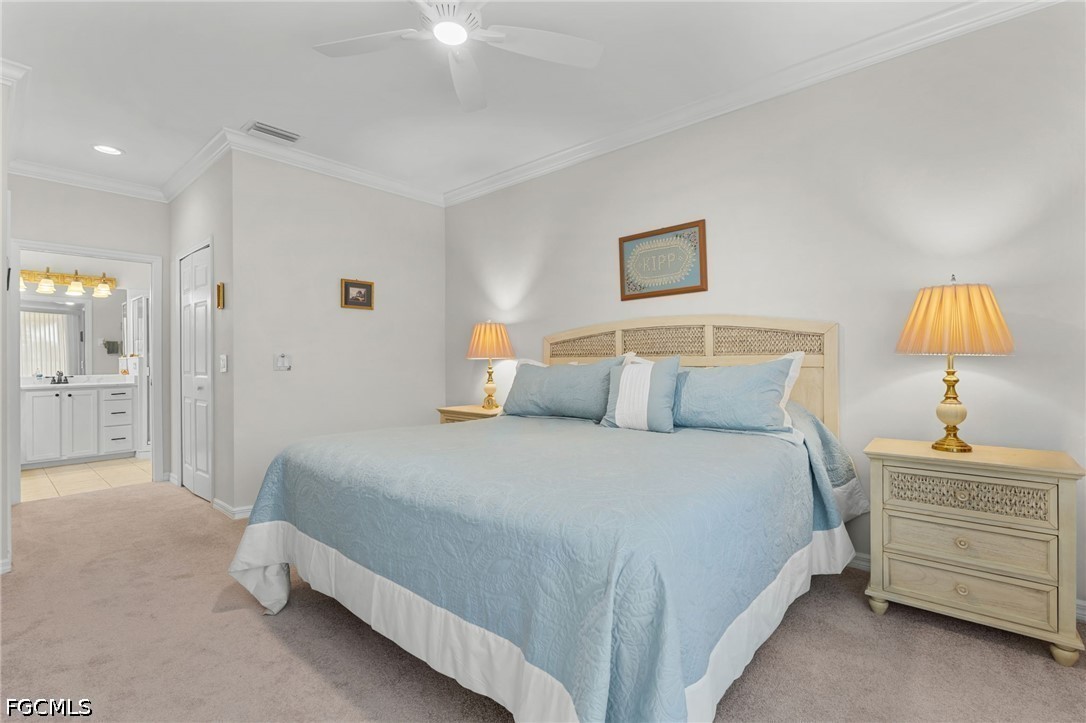 Furnished bedroom with a large bed, light blue bedding, and a woven headboard; bathroom visible through doorway.
