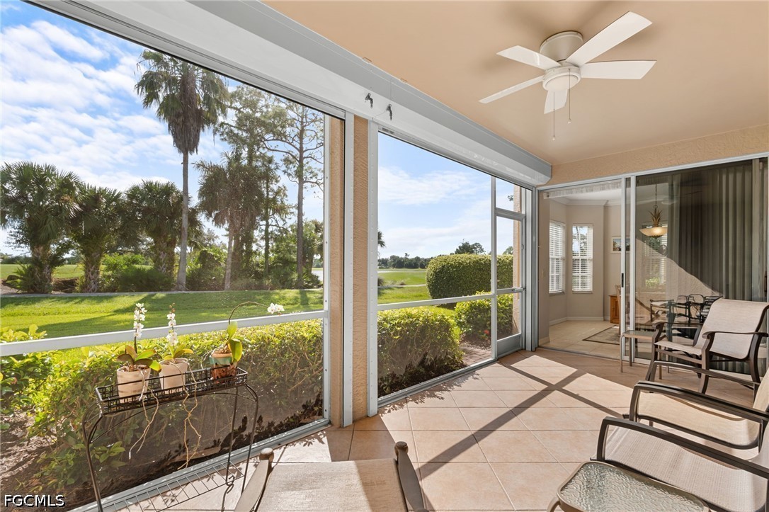 Screened lanai with patio seating overlooking a golf course.