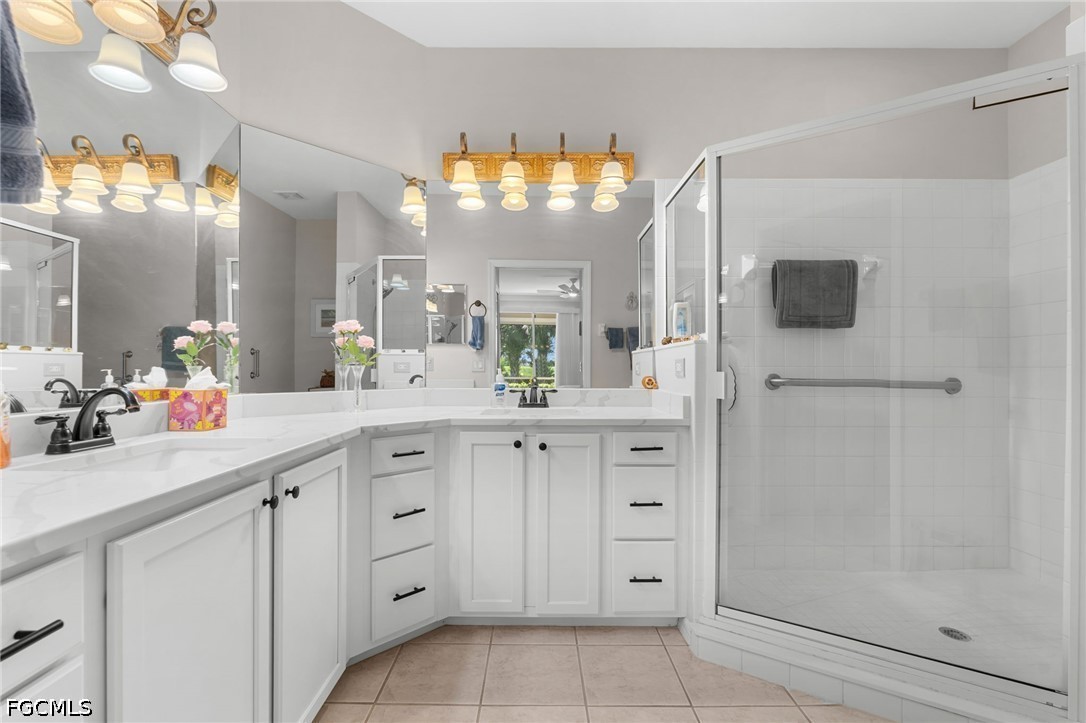 Bathroom with a mirrored white vanity and a spacious glass-enclosed shower.