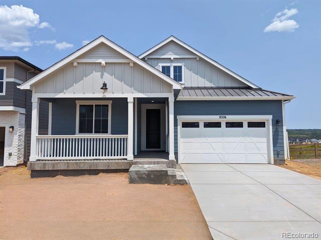 Blue-gray single-story house with a covered porch, white railing, and two-car garage.