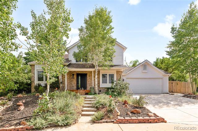 Two-story brick-and-siding house with an attached garage and landscaped front yard.