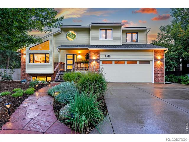 Two-story home with brick accents, an attached garage, and a landscaped stone walkway at dusk.