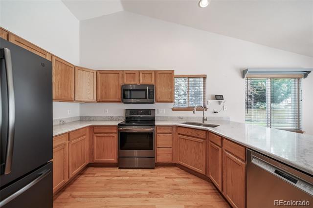 Kitchen with wood cabinets, stainless steel appliances, and hardwood floors.