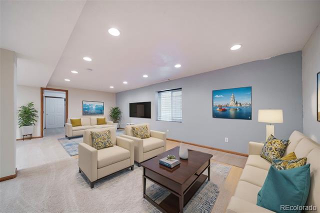 Living room with cream seating, a dark wood coffee table, and gray accent wall.