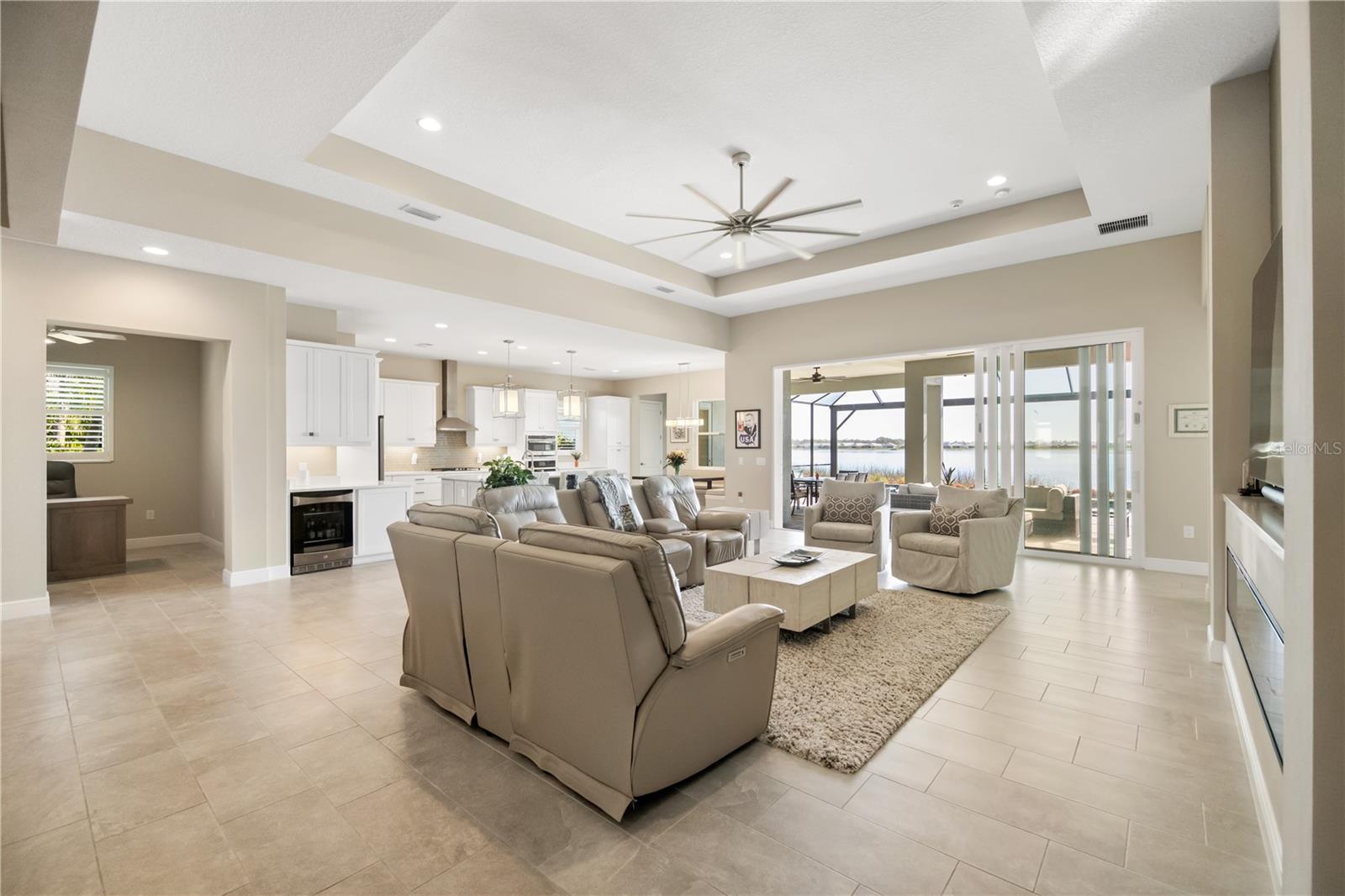 Open-plan living room and kitchen with sliding glass doors overlooking the water.