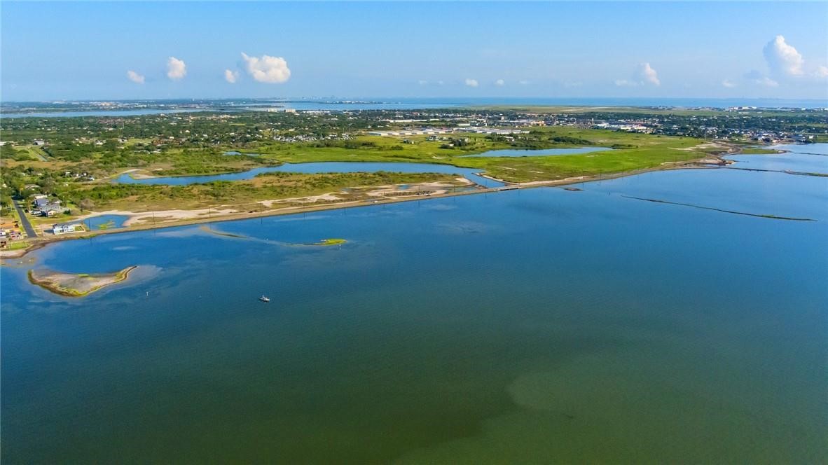 Aerial view of a coastal lagoon, with wetlands and scattered development along the distant shore.