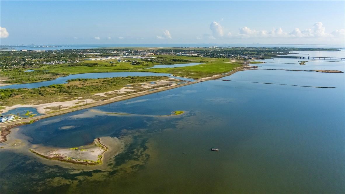 Aerial view of Laguna Shores with coastal wetlands, shoreline road, and a bridge across the water.