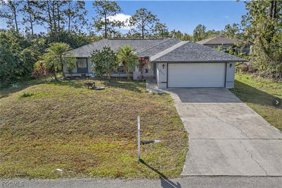 Single-story gray house with an attached two-car garage and broad driveway.