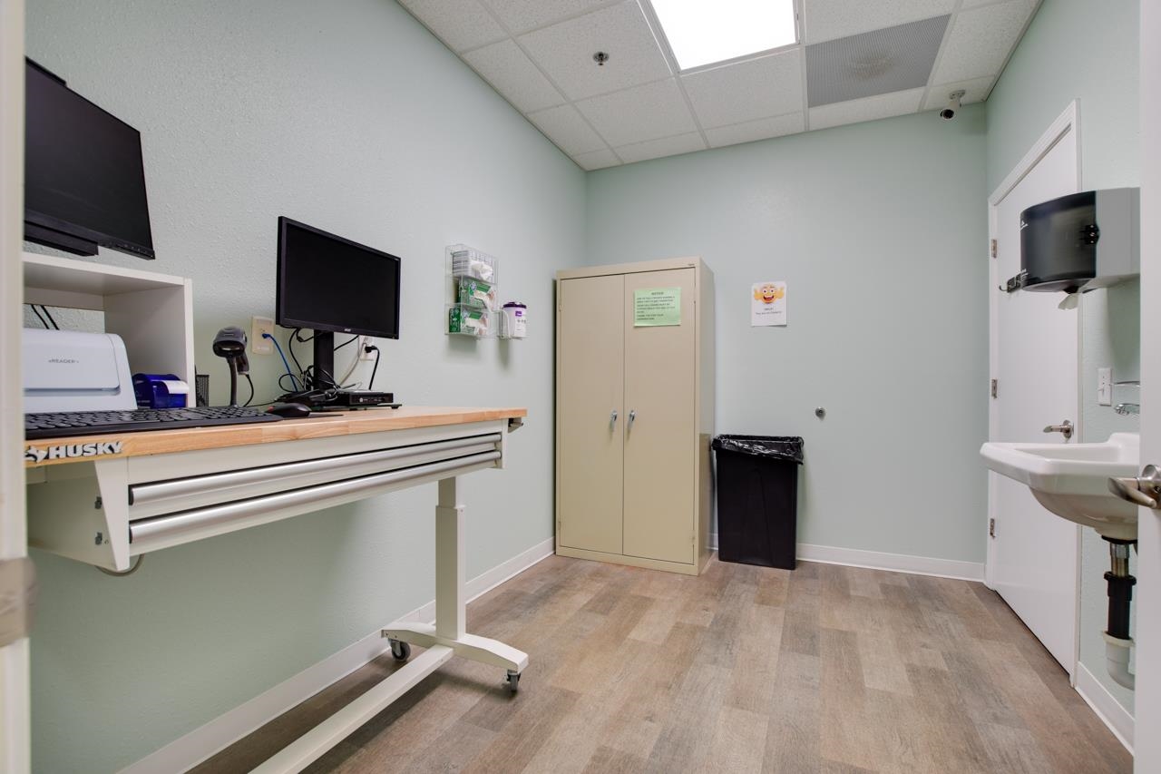 Equipped workroom with a mobile workbench, storage cabinet, and wall-mounted sink.