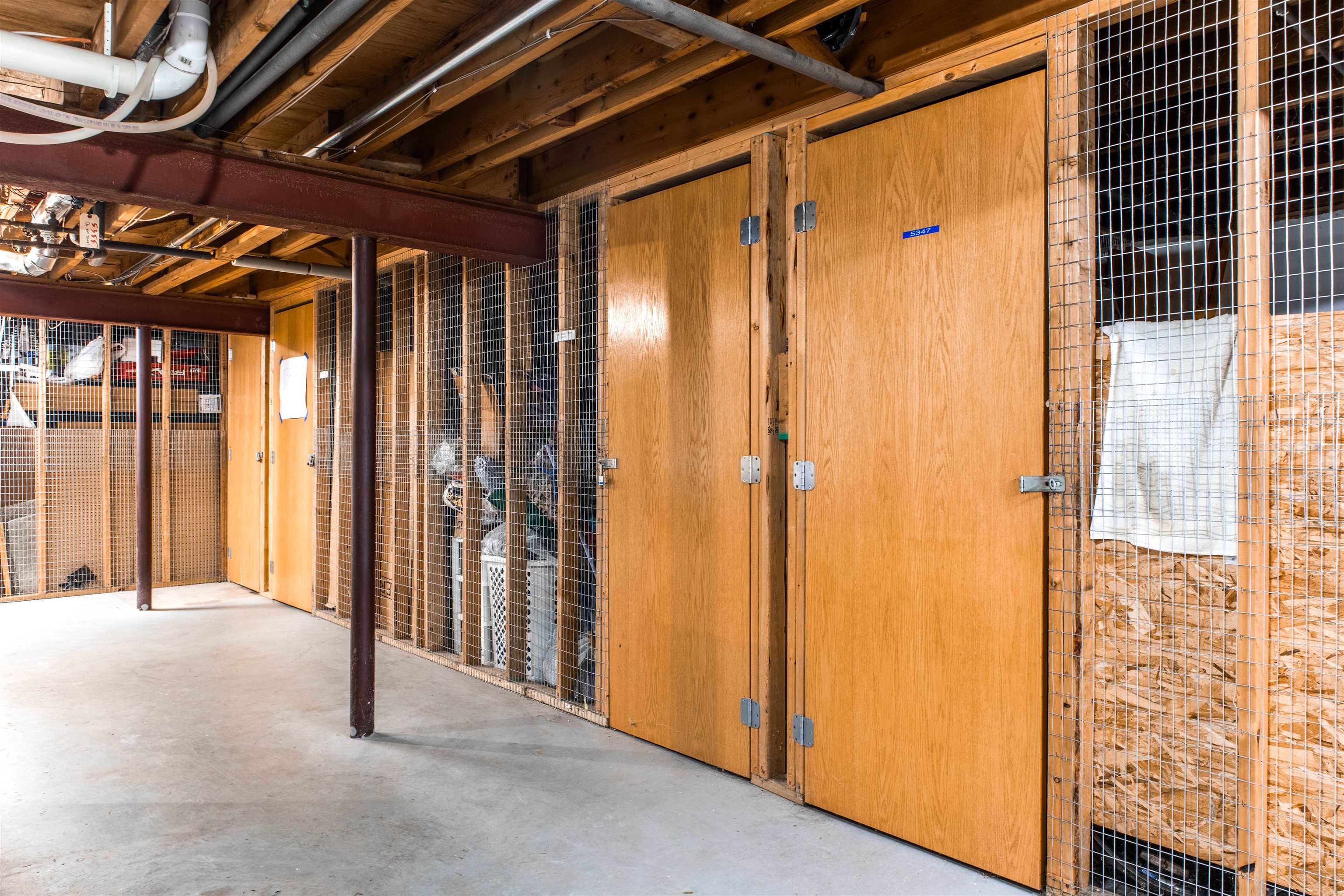 Storage area with wooden locker doors and wire-mesh partitions.