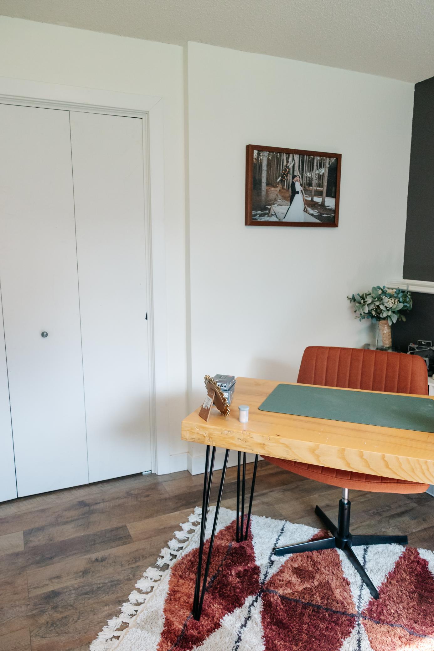 Furnished room with a light wood table, rust-colored chair, and patterned rug.