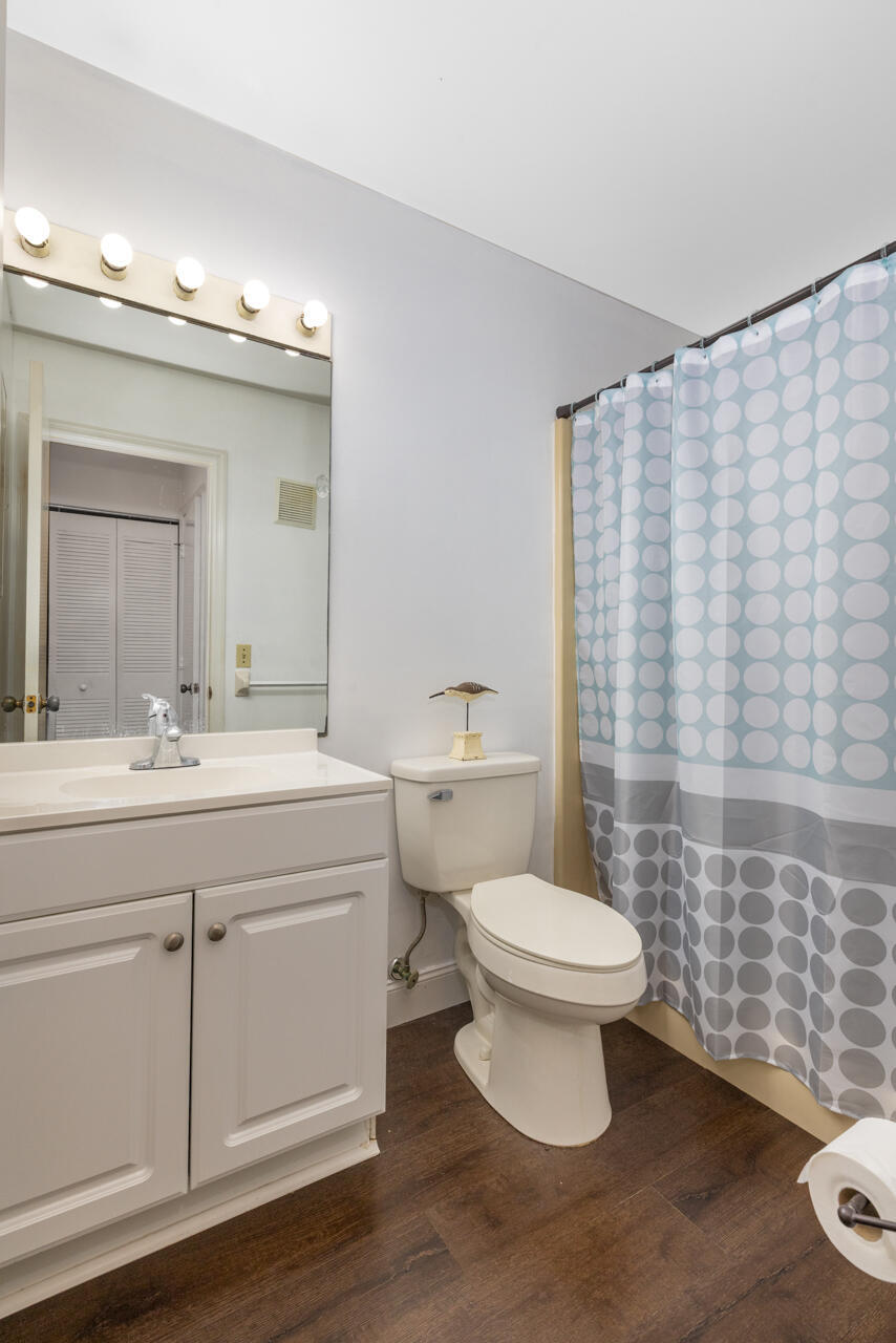 Bathroom with a white vanity, toilet, and blue-and-gray circular-patterned shower curtain.
