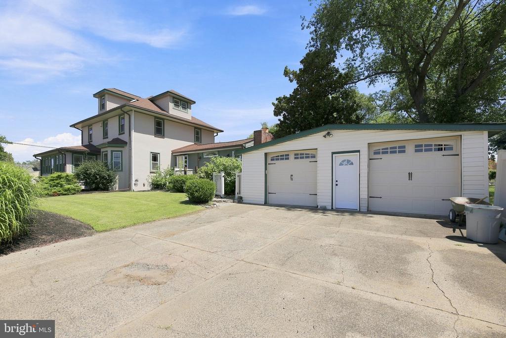 Two-story house beside a detached two-car garage and broad concrete driveway.