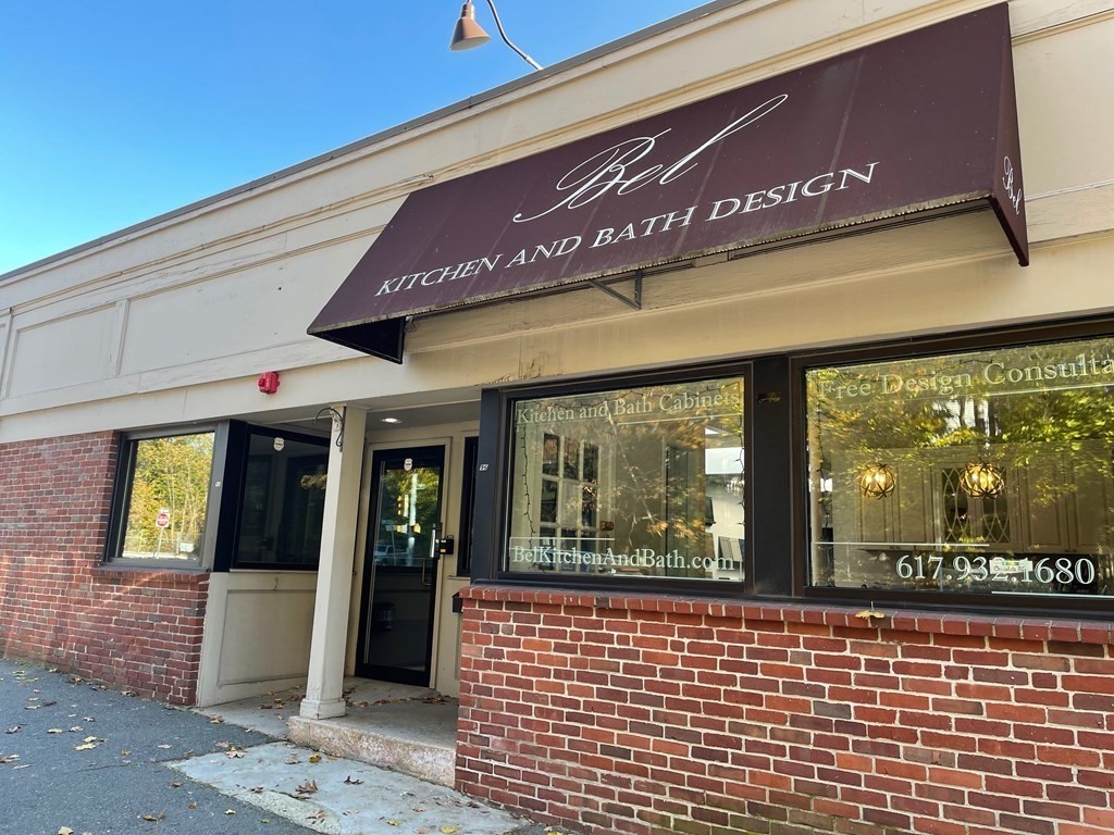 Kitchen and bath design storefront with a burgundy awning and red-brick facade.