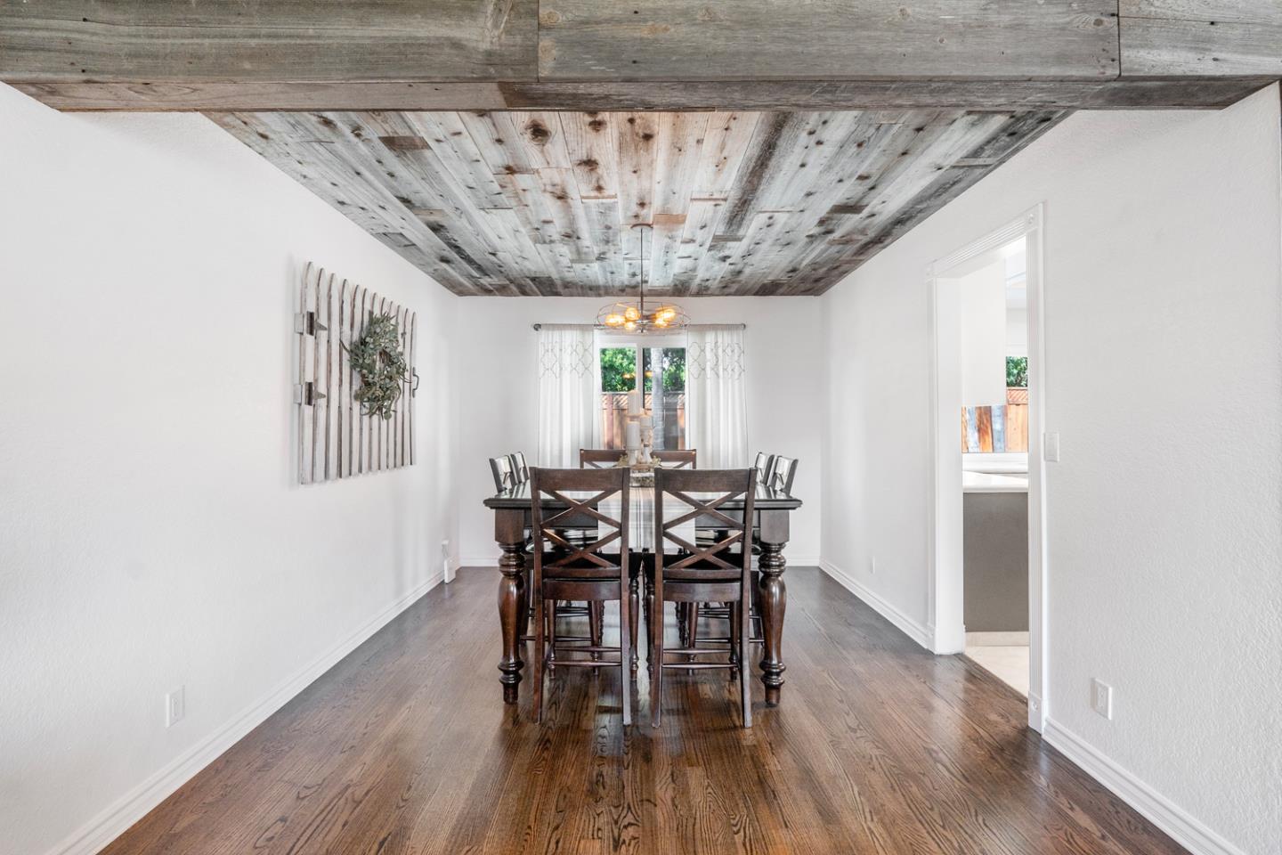 Dining room with a reclaimed-wood ceiling, dark wood table, and hardwood floors.