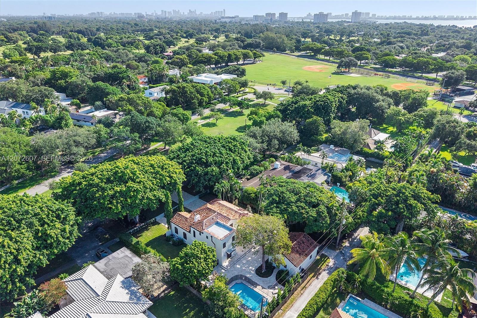 Aerial view of the Miami Shores home and pool, with parkland and baseball fields beyond.