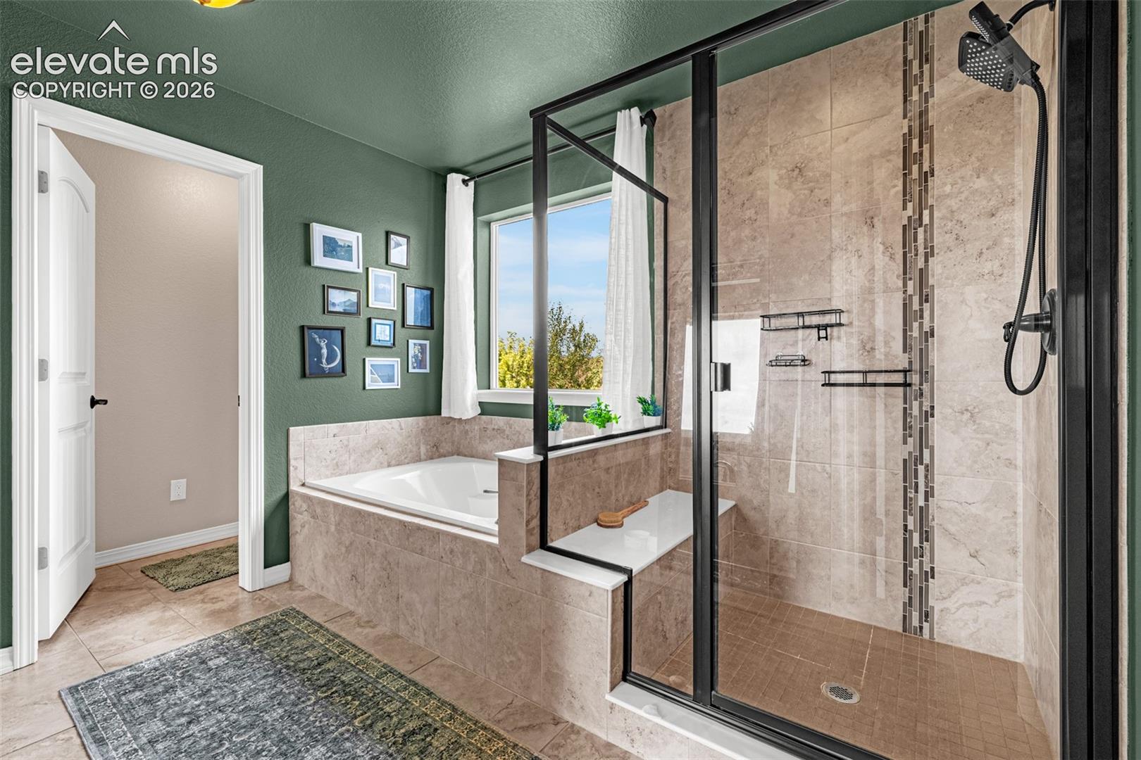 Bathroom with a tiled soaking tub and spacious glass-enclosed walk-in shower.